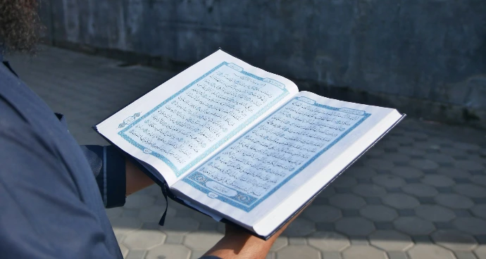 a man holding an open book with numbers on it